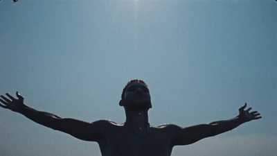 a man with his arms outstretched in front of a blue sky