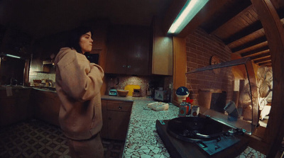 a woman standing in a kitchen next to a stove top oven