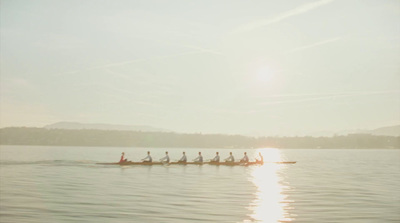 a group of people rowing a boat on a lake