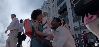 a group of people walking down a street next to tall buildings