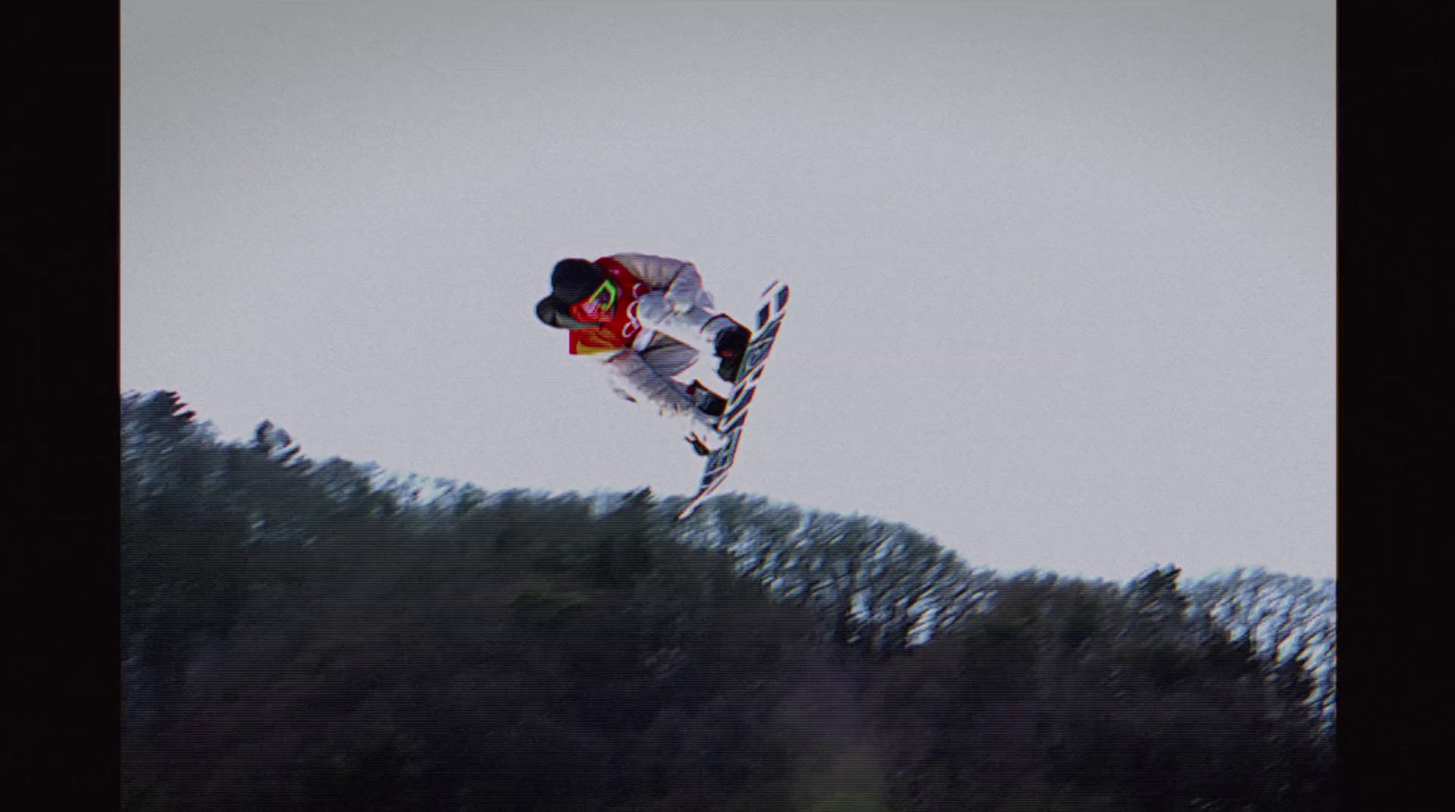 a man flying through the air while riding a snowboard