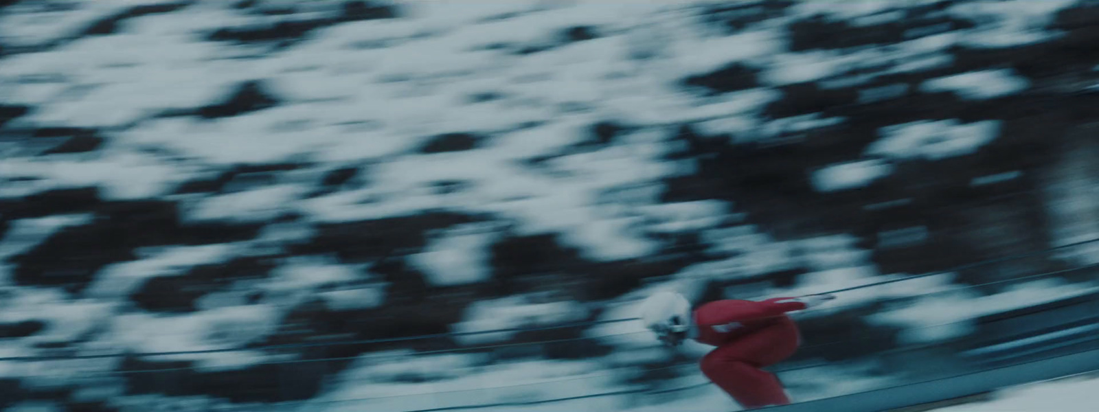 a man riding a snowboard down a snow covered slope