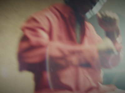 a blurry image of a man in a red jacket and tie