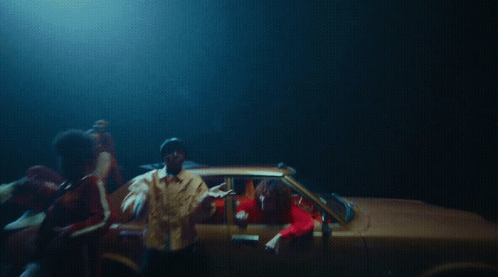 a group of people standing in front of a car