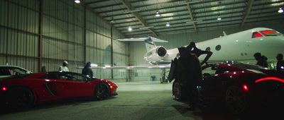 a group of people standing around a red sports car