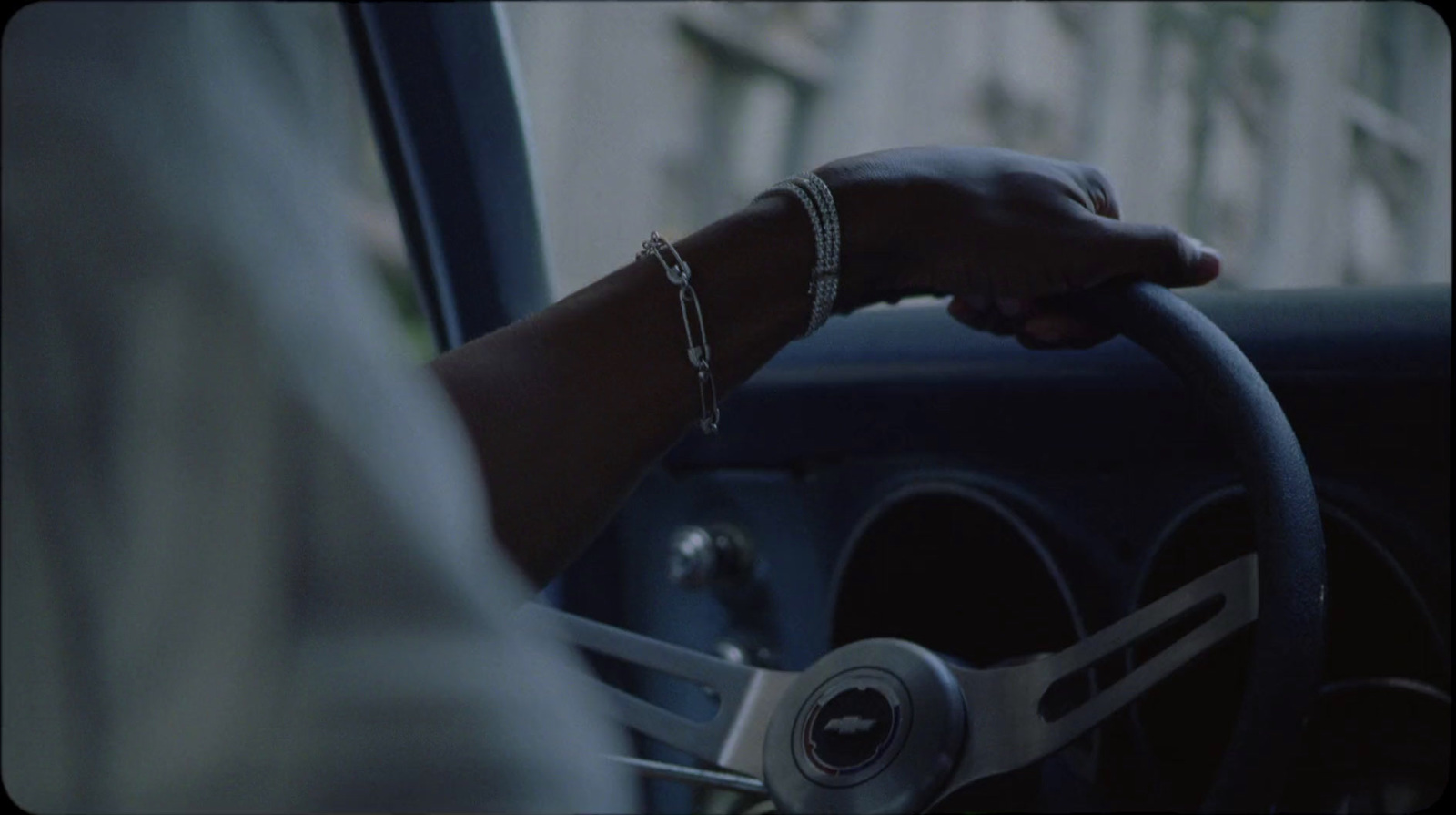 a person holding a steering wheel while driving a car