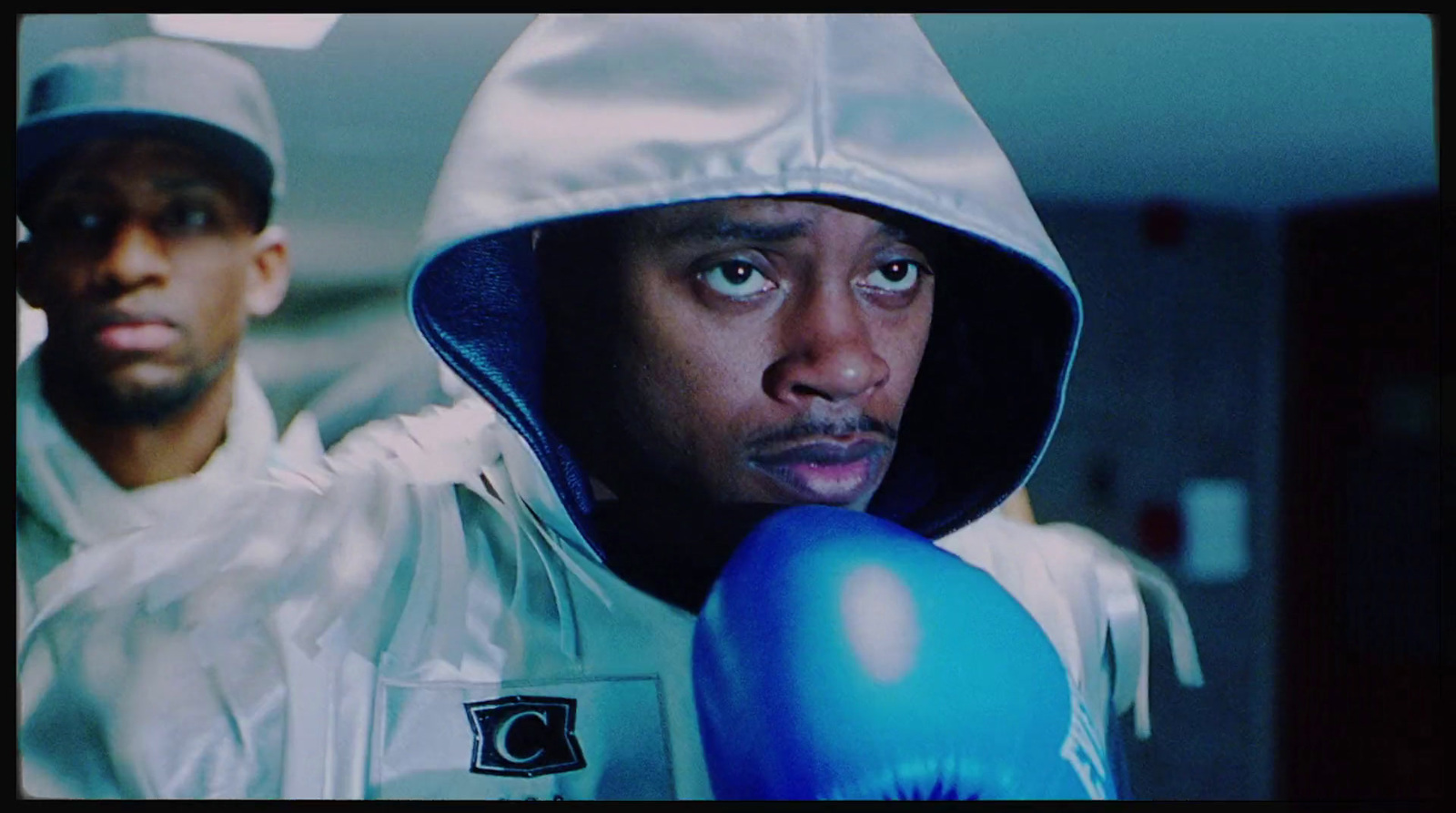 a man wearing a hoodie and boxing gloves