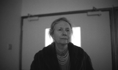 a woman in a black jacket looking into a mirror