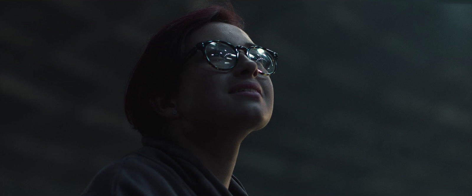 a woman wearing glasses looking up into the sky