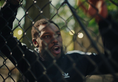 a man standing behind a chain link fence