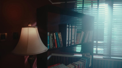 a lamp and bookshelf in a dark room