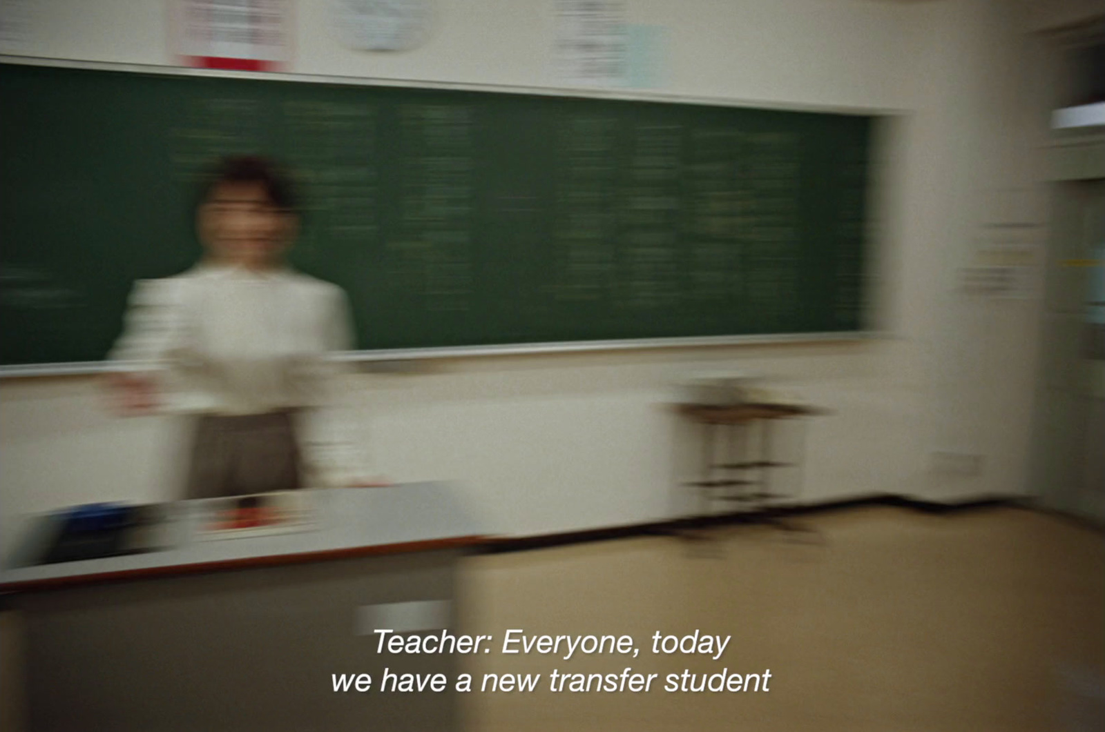 a woman standing in front of a blackboard in a classroom