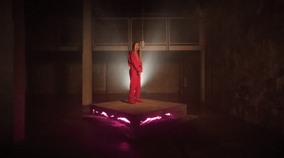 a woman in a red suit standing on a platform