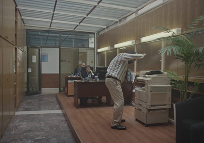 a man is standing in an office with a lot of boxes