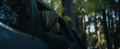 a woman is looking out the window of a car