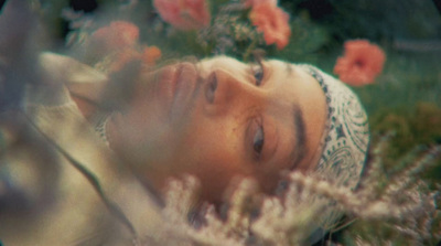 a woman laying down in a field of flowers