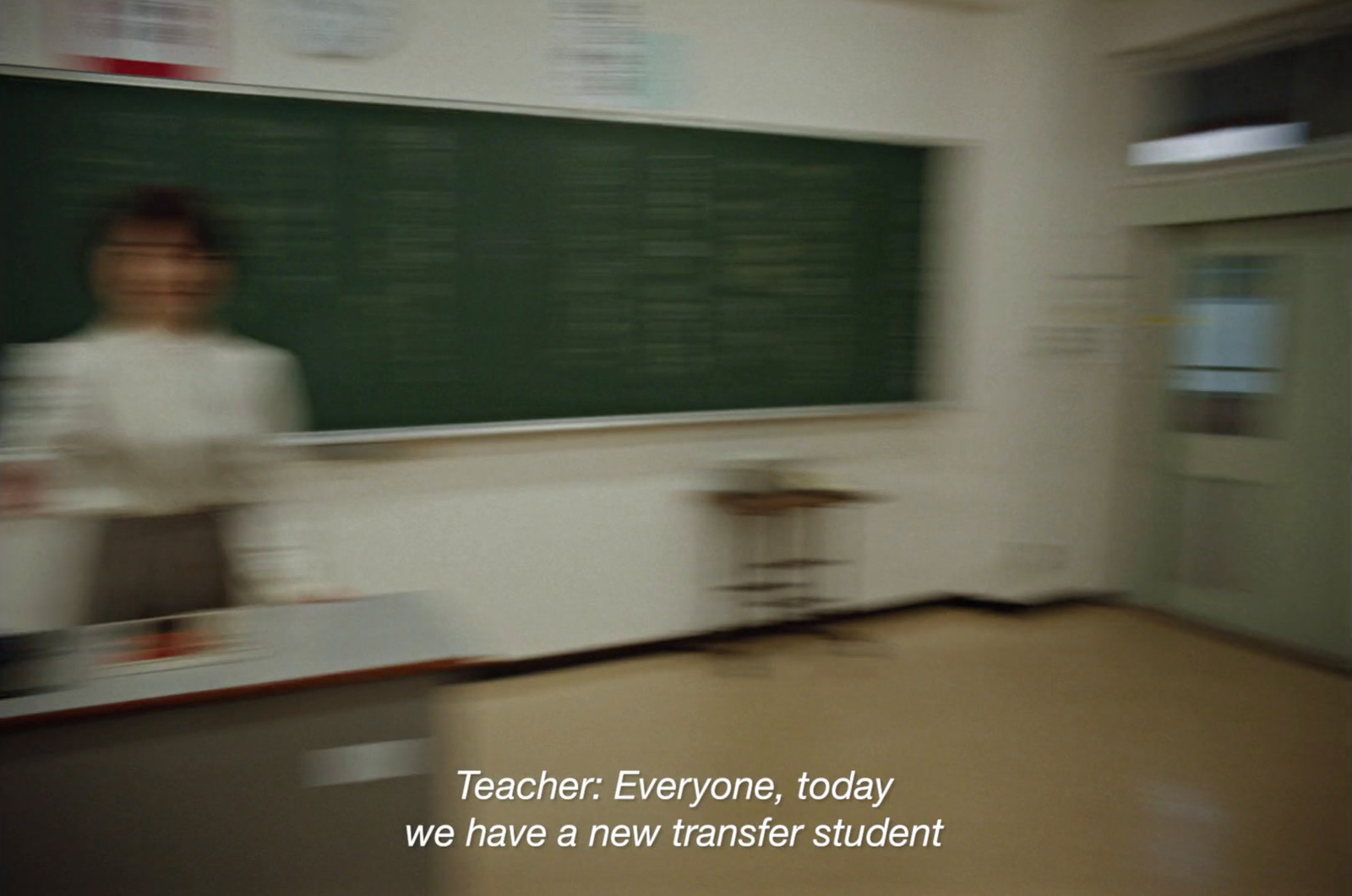 a blurry photo of a teacher in front of a blackboard