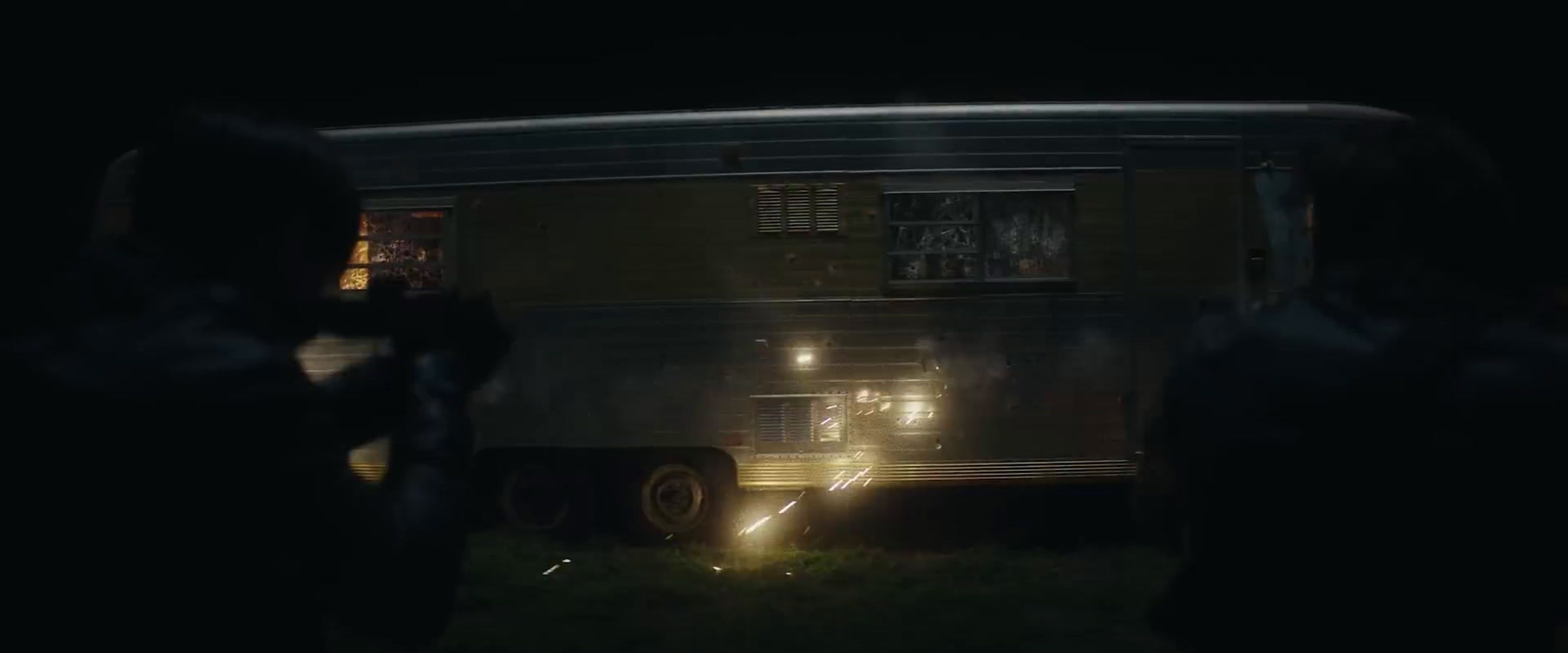 a group of people standing in front of a bus at night