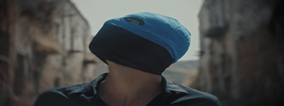 a man with a blue head covering on his face