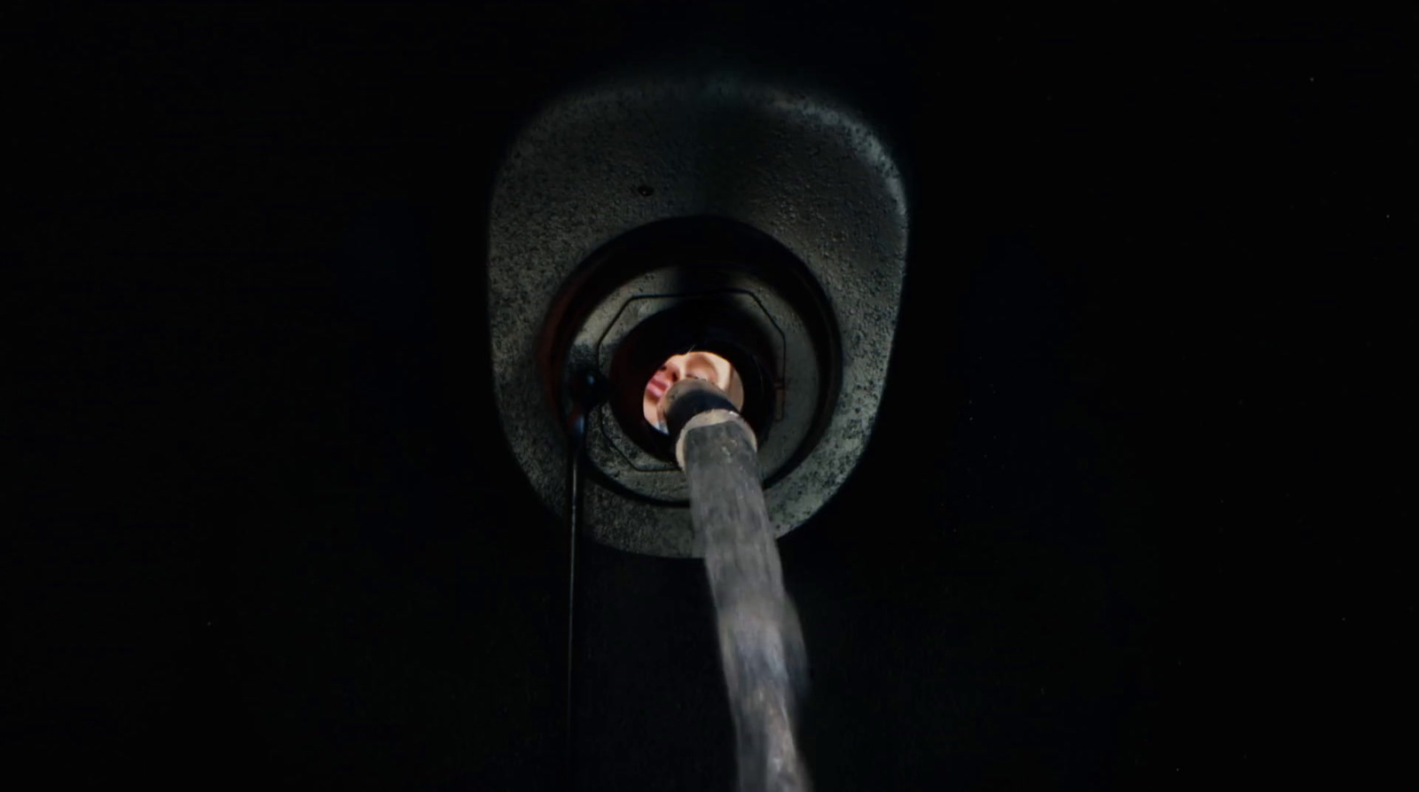 a person's hand coming out of a pipe in the dark