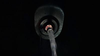 a person's hand coming out of a pipe in the dark