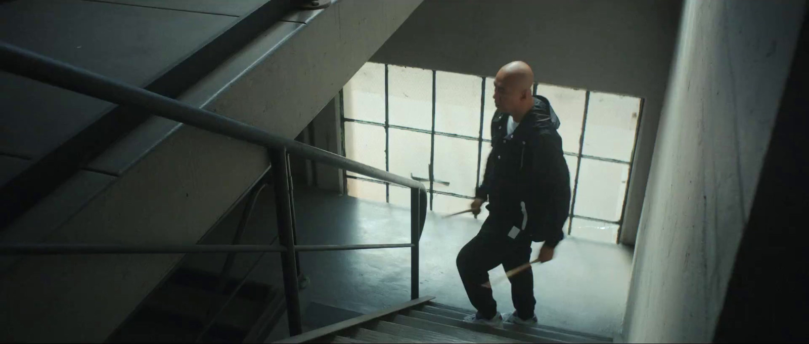 a bald man walking down a flight of stairs