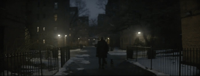 a person walking down a snowy street at night