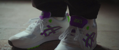 a close up of a person's white and purple sneakers