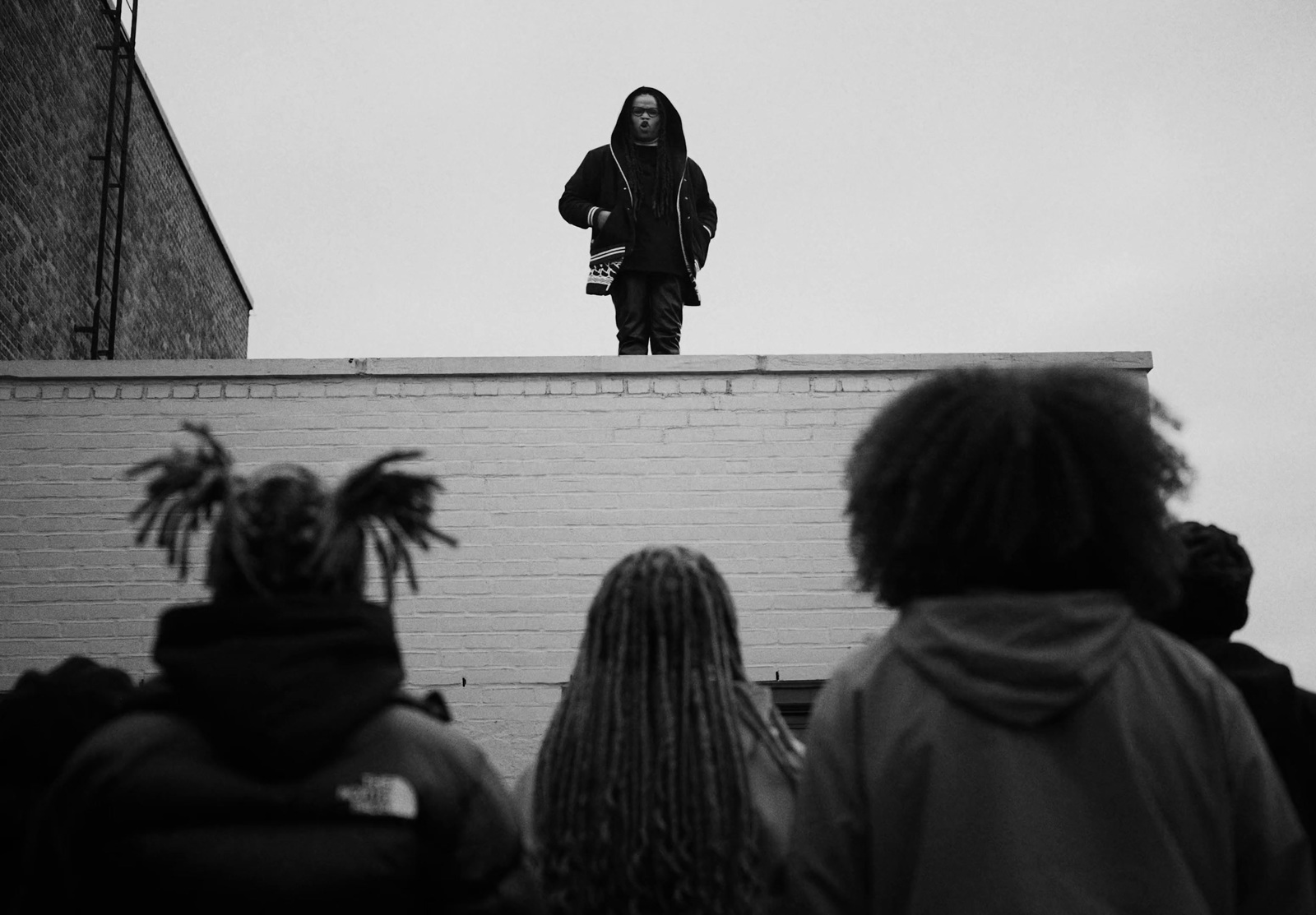 a man standing on top of a brick wall