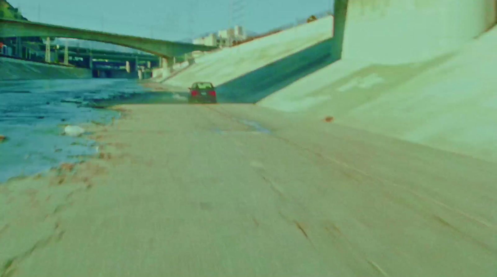 a car driving down a road next to a bridge