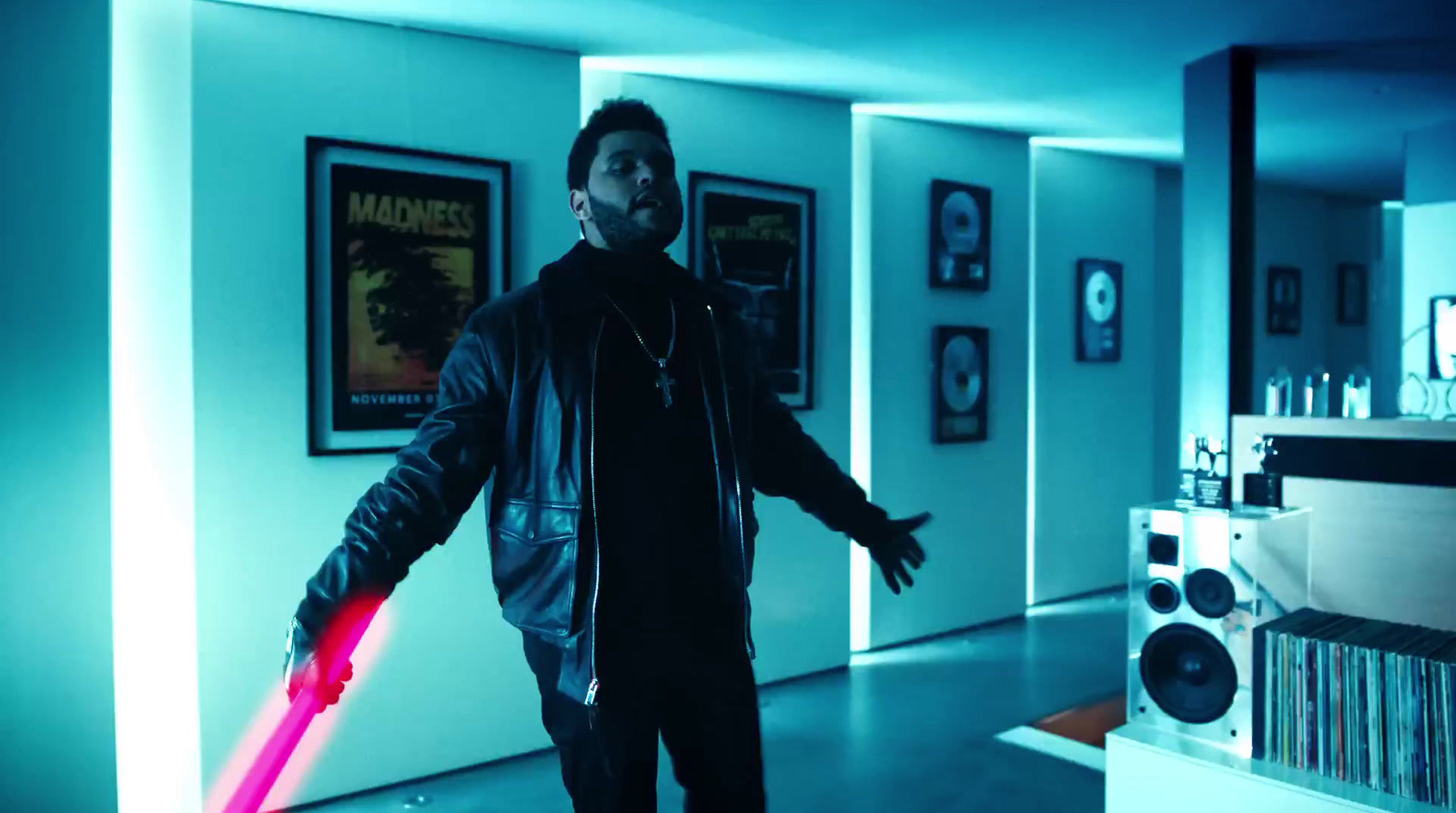 a man holding a red light saber in a room