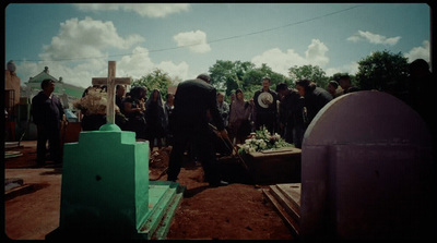 a group of people standing around a grave