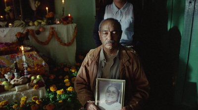 a man holding a picture of himself in front of flowers