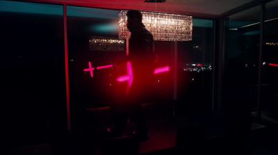 a person standing in a dark room with a chandelier