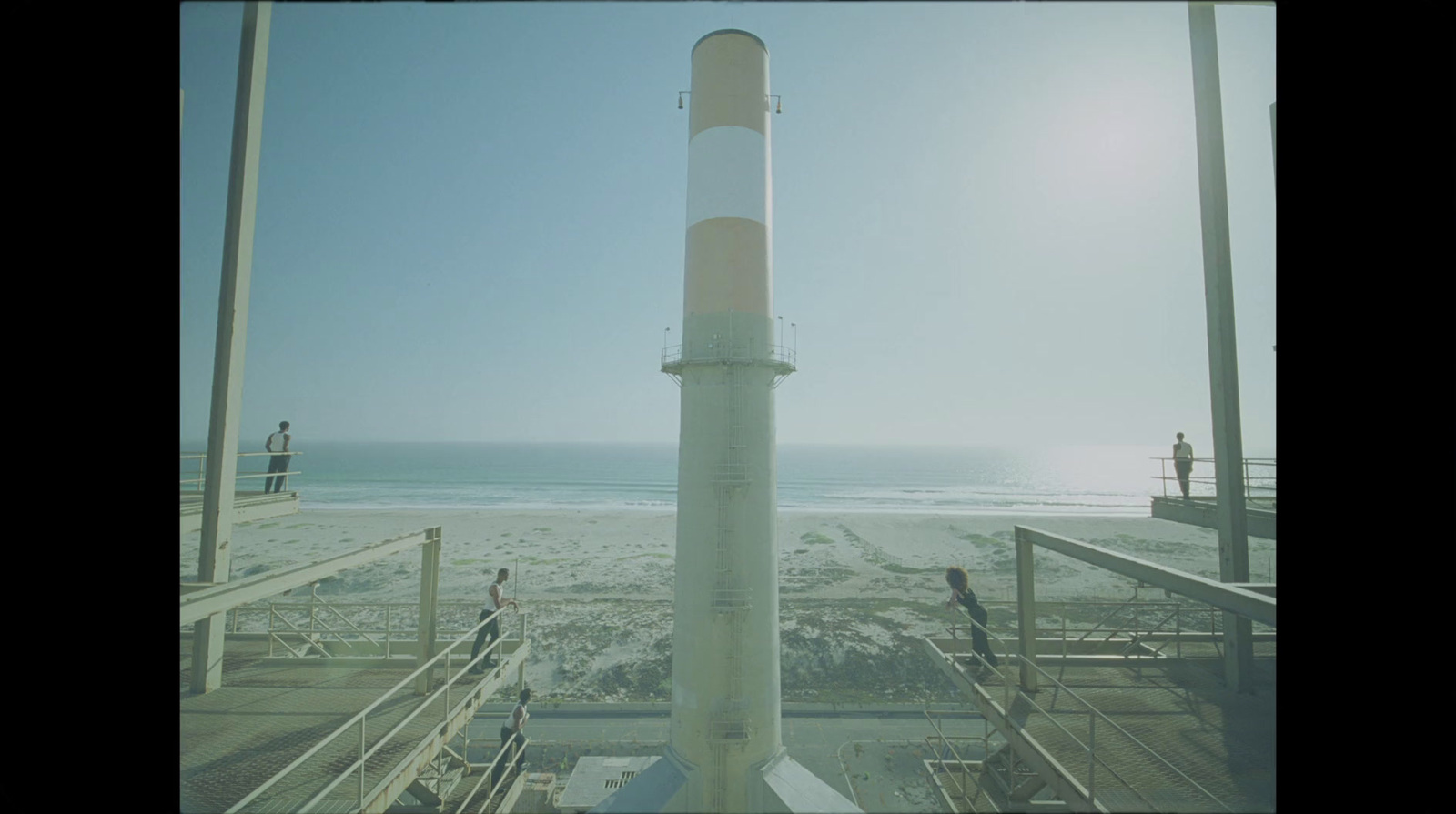 a tall white tower sitting on top of a sandy beach