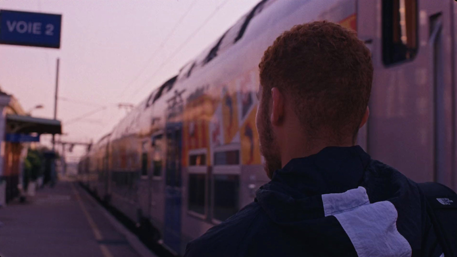 a man standing next to a train at a train station