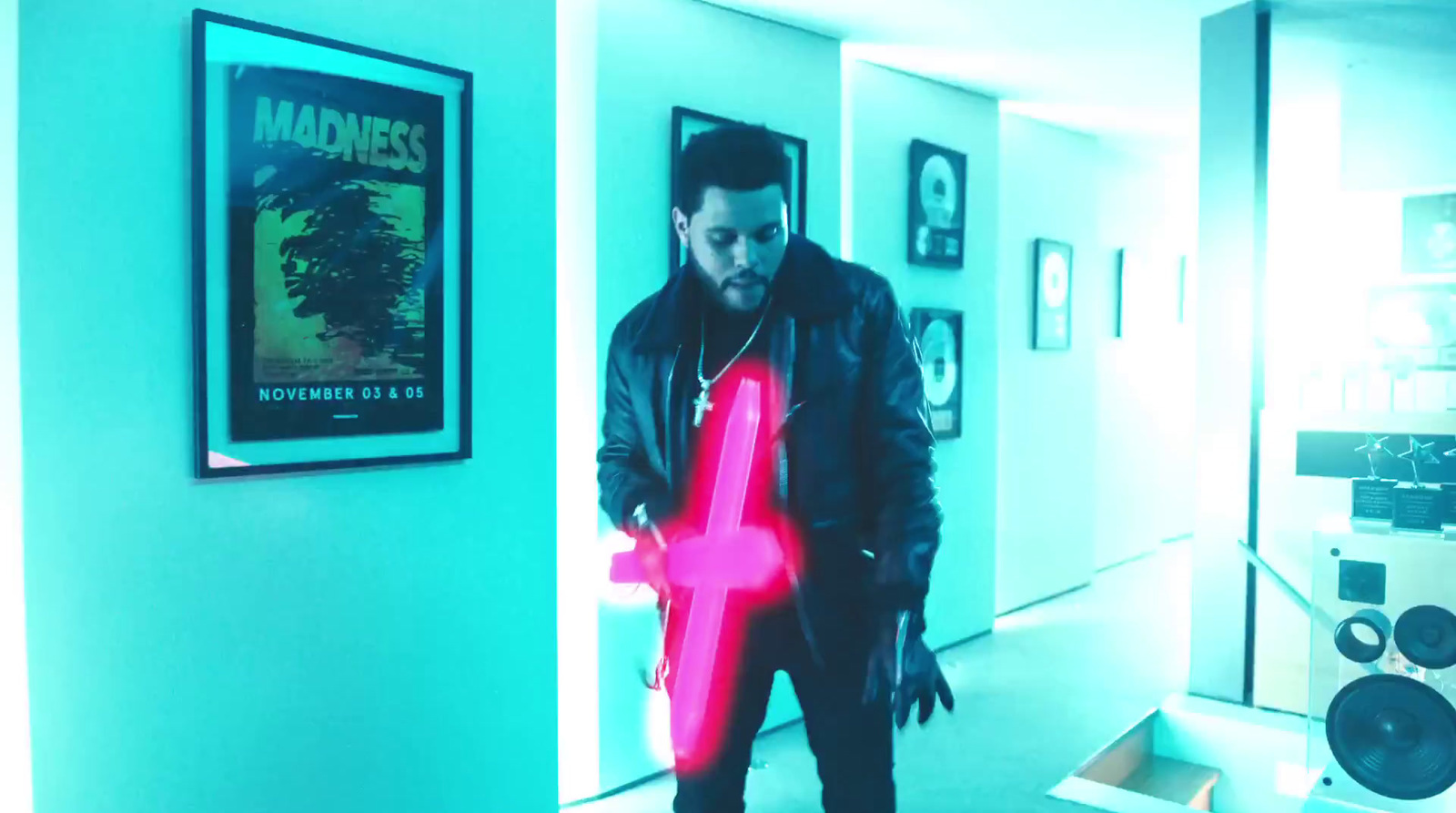 a man standing in a hallway holding a neon letter