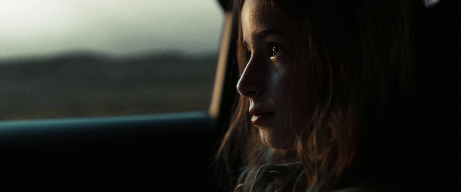 a young girl sitting in the passenger seat of a car