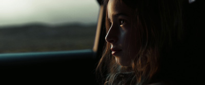 a young girl sitting in the passenger seat of a car