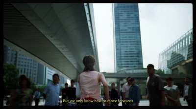 a group of people walking down a street next to tall buildings