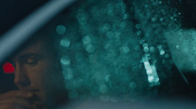 a man sitting in a car looking out the window