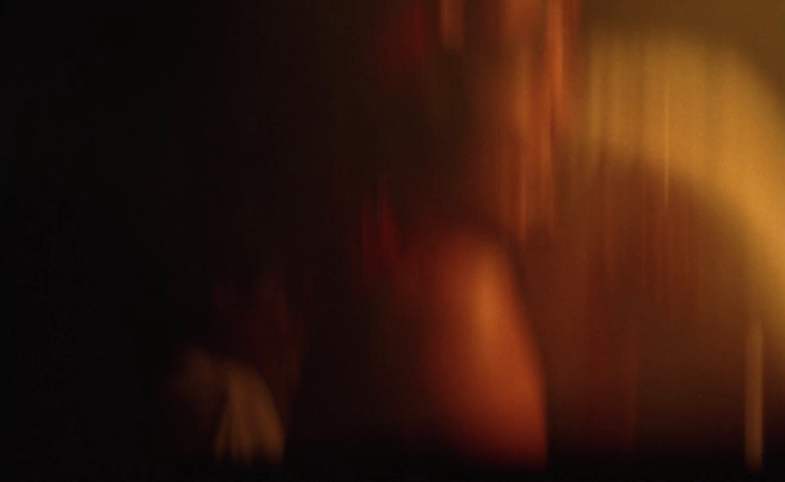 a blurry photo of a woman's back in a dark room