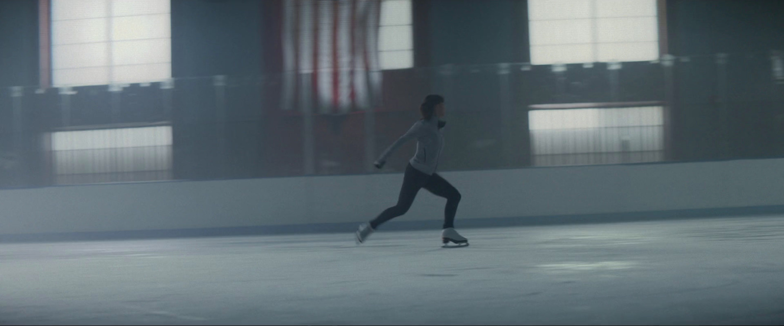 a person skating on an ice rink in a building