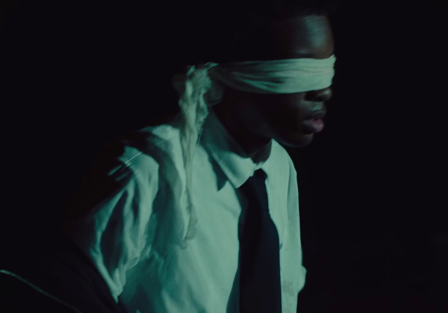 a man wearing a tie and a blindfold