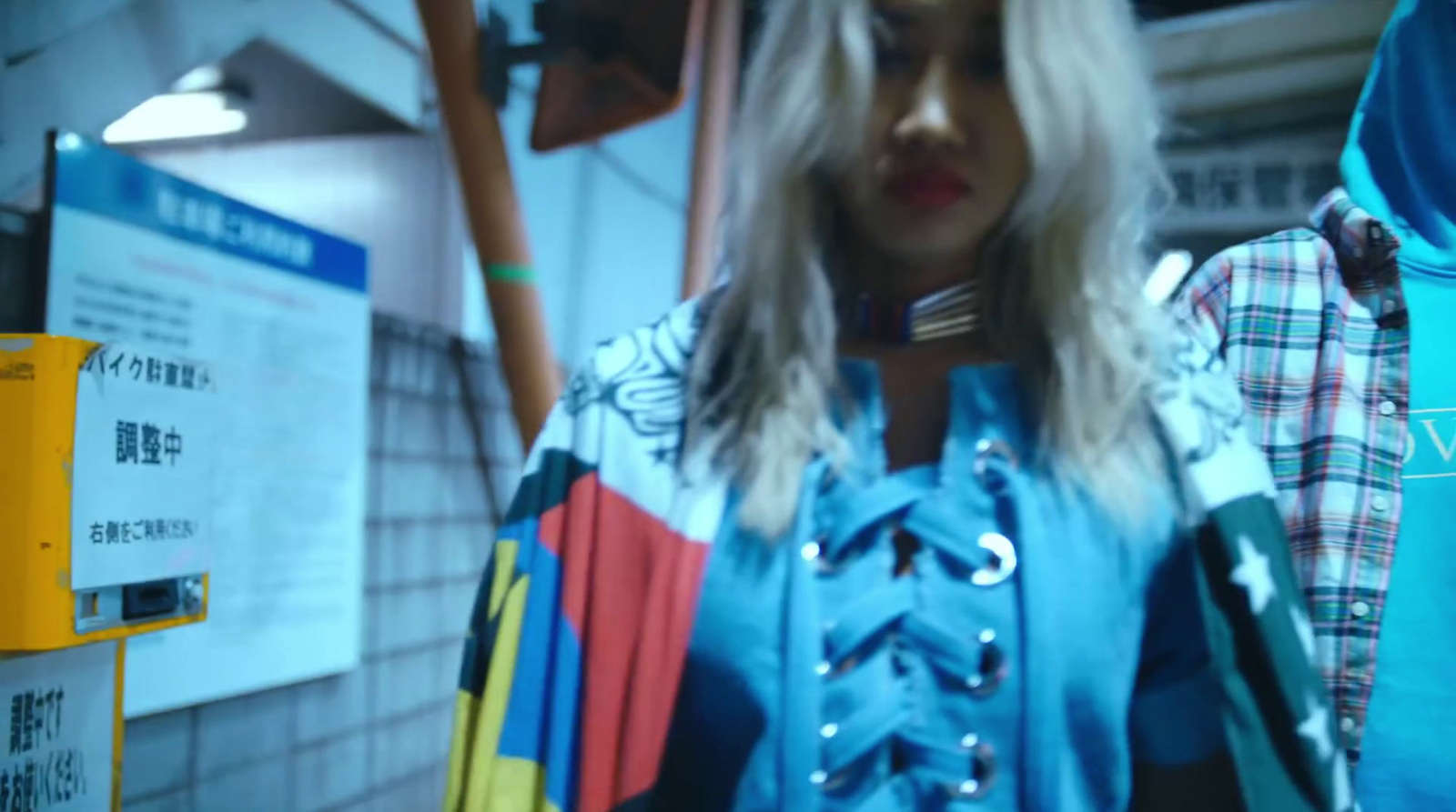 a woman standing in front of a rack of clothes