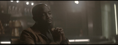 a man sitting in a chair in a dimly lit room