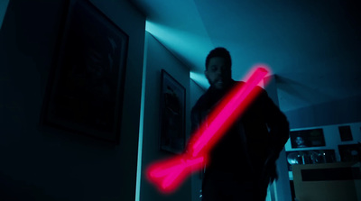 a man holding a red light saber in a dark room