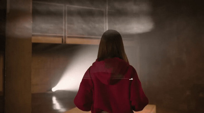 a woman in a red jacket standing in a room