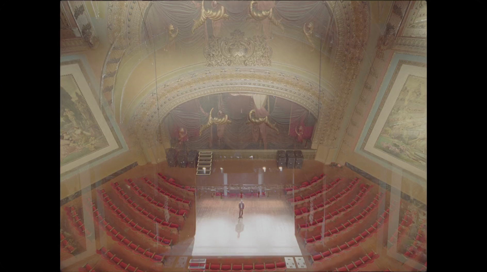 a large auditorium with a lot of red chairs