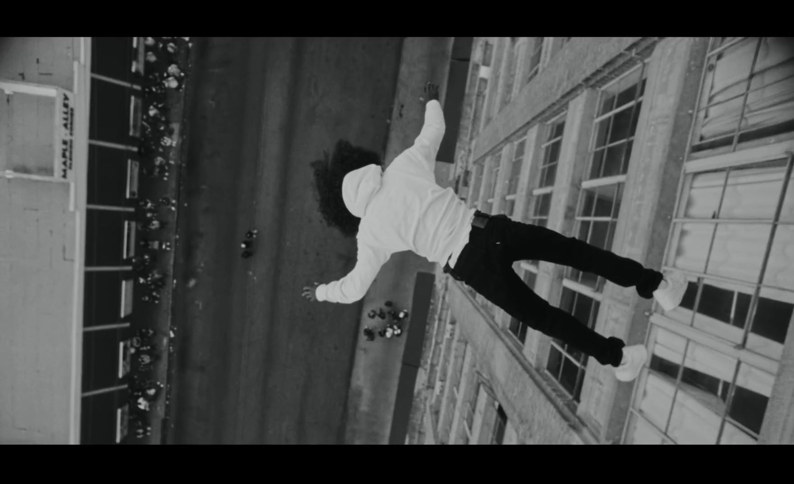 a man in white shirt and black pants doing a trick on a skateboard